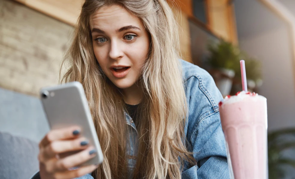Žena sleduje časovač zľavy na mobile a rozhoduje sa, či klikne na kúpiť teraz
